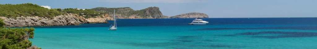 Vista panorámica de la costa de Ibiza con acantilados de piedra caliza y aguas turquesas del Mediterráneo durante una ruta de coasteering